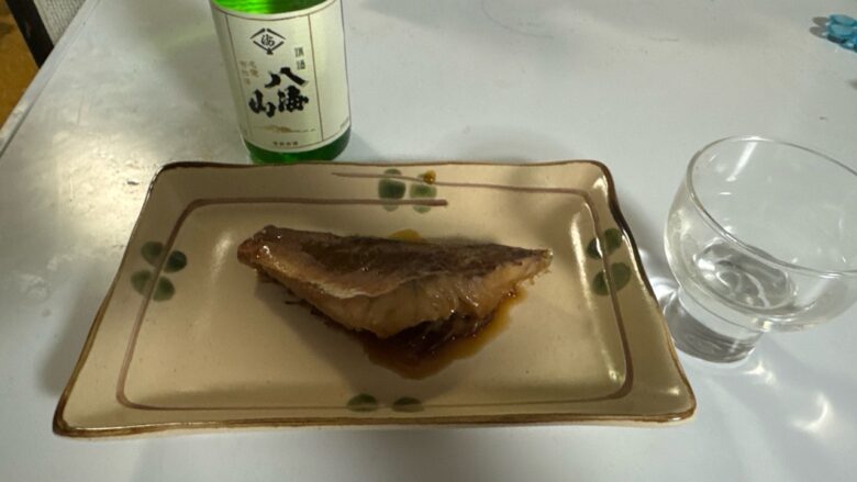皿に盛り付けた映画ちいかわ赤魚の煮付と八海山と日本酒グラス