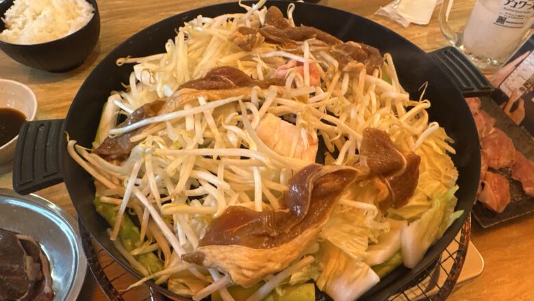 野菜の上に肉をのせてジンギスカンを焼いている様子