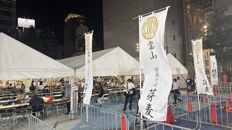 夜のラー1グランプリ2026会場のテント席と清湯そば 芽麦ののぼり